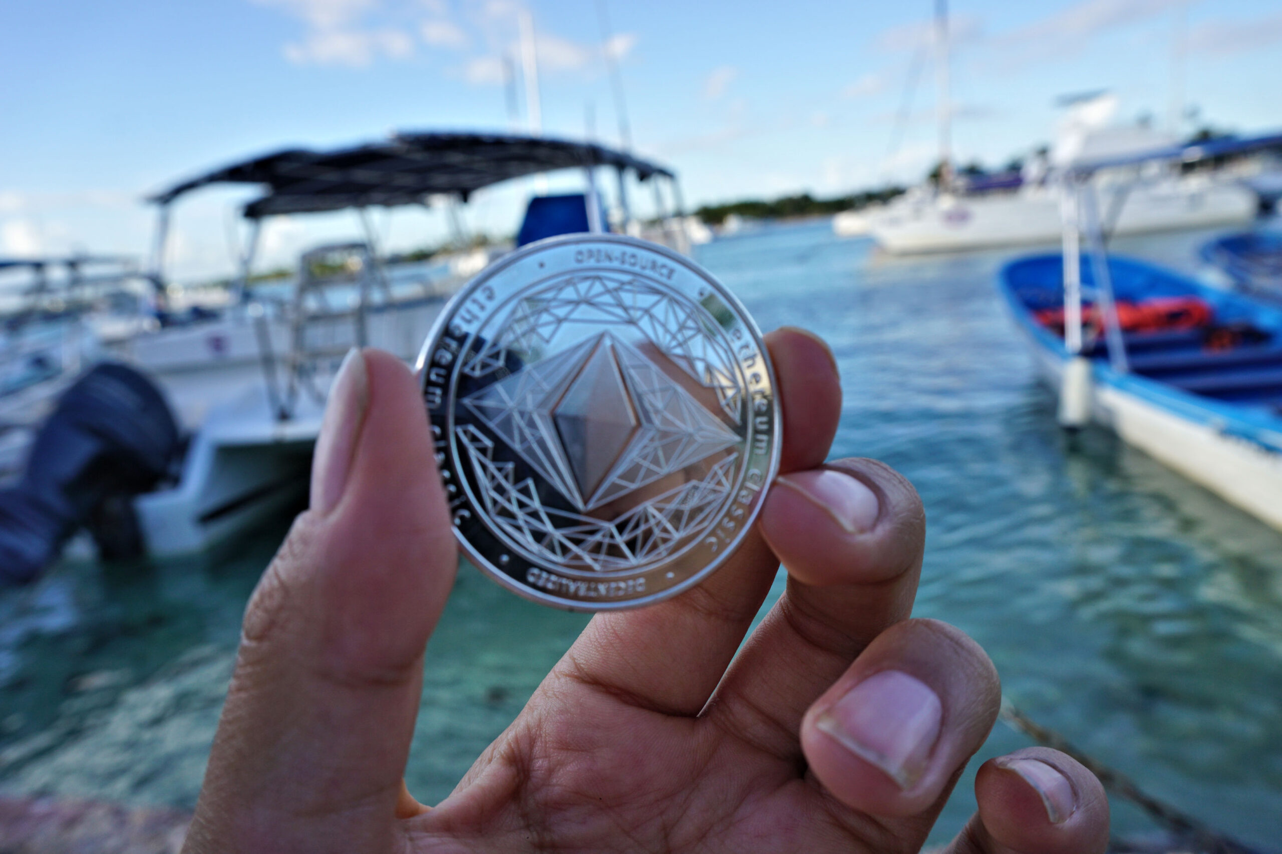 Ethereum ($ETH) Coin Held In Front of Caribbean Ocean Boat Dock Ⓒ 2023 – Crypto Coin Opps