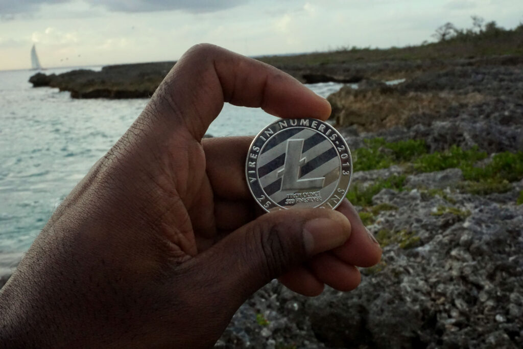 Litecoin [$LTC] Token In Front of Sailboat on Caribbean Ocean Ⓒ 2023 – Crypto Coin Opps