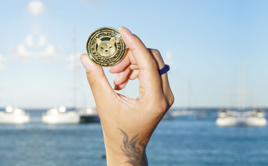 Shiba Inu ($SHIB) Token held in front of Bayahibe (Dominican Republic) Piers Ⓒ 2023 – Crypto Coin Opps
