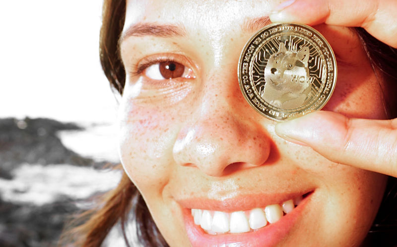 Woman Holding DogeCoin ($DOGE) Token Over Eye Ⓒ 2023 – Crypto Coin Opps