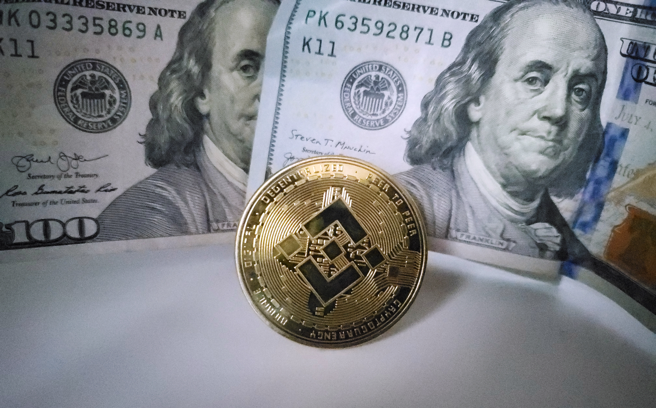 Bnnace in front of US Hundred Dollar Bills Ⓒ 2023 – Crypto Coin Opps