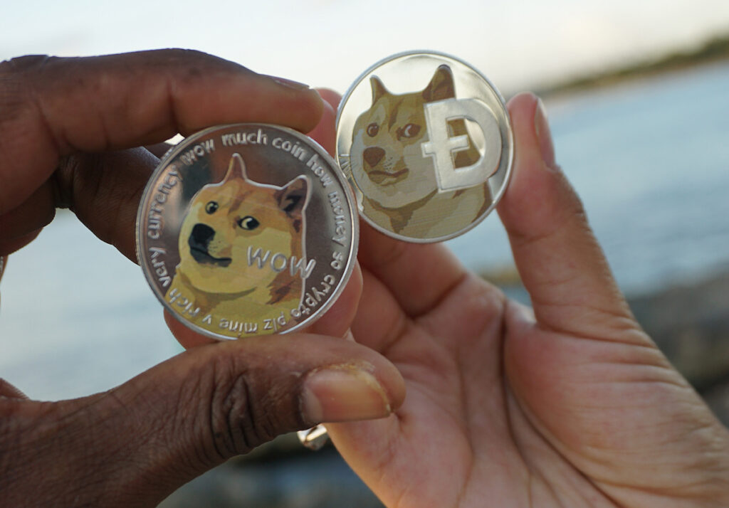 Two people holding Dogecoin ($DOGE) TokensⒸ 2023 – Crypto Coin Opps