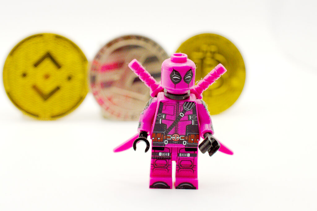 Fuschia Lego Ninja Standing In Front of Cryptocurrency Ⓒ 2023 – Crypto Coin Opps